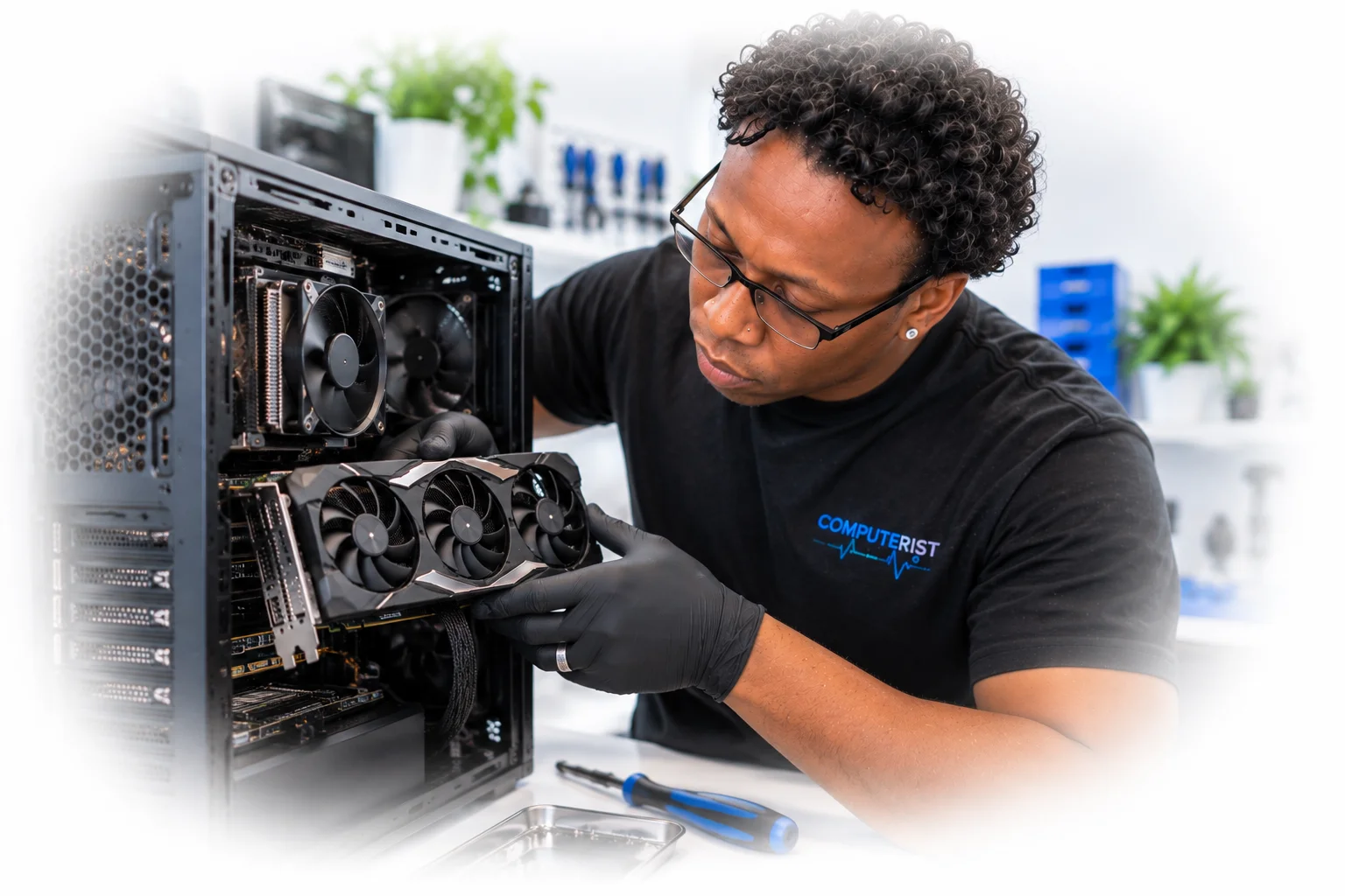 Computer technician preparing a graphics card for installation in a desktop PC.
