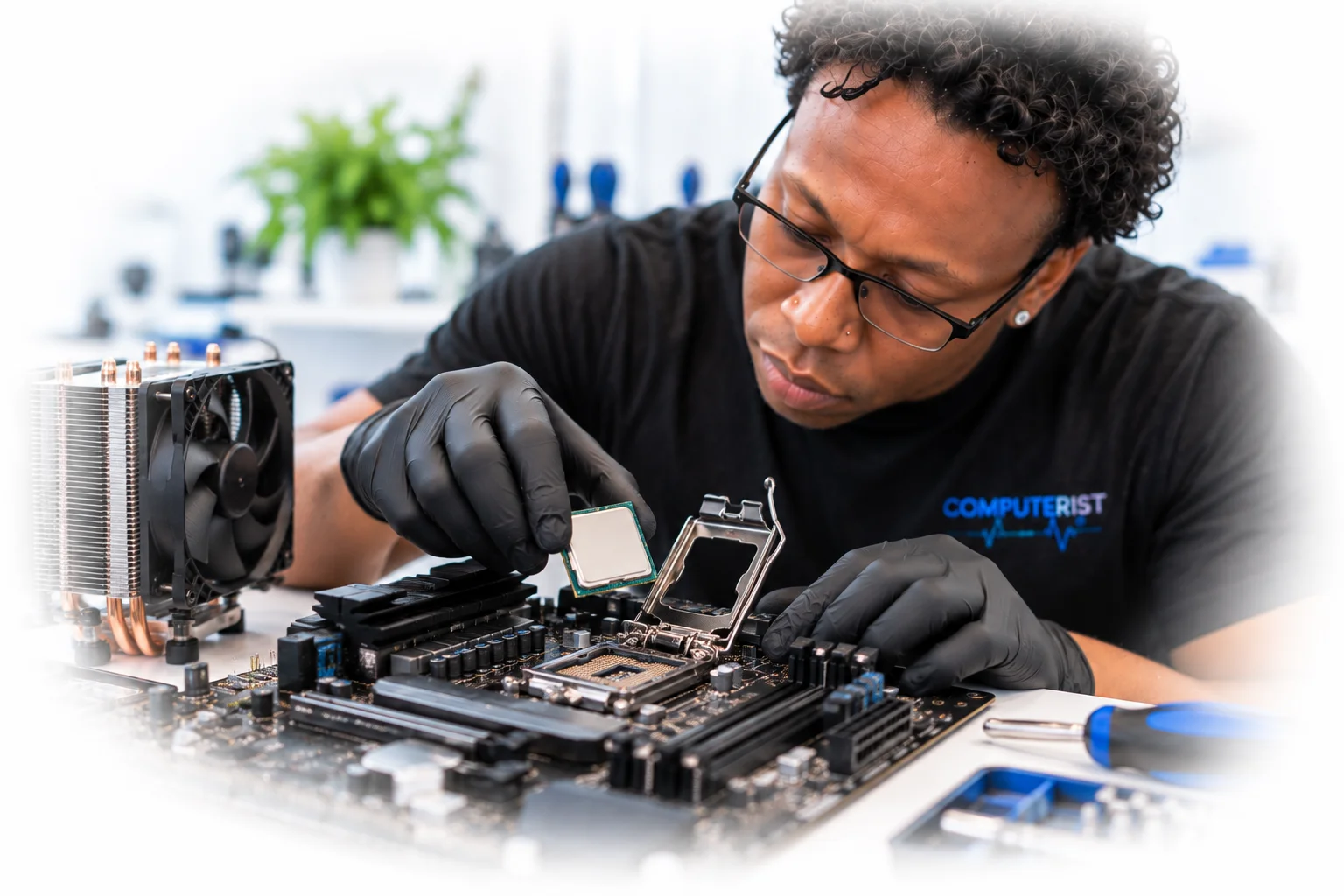 Computer technician carefully positioning a CPU above a desktop motherboard socket.
