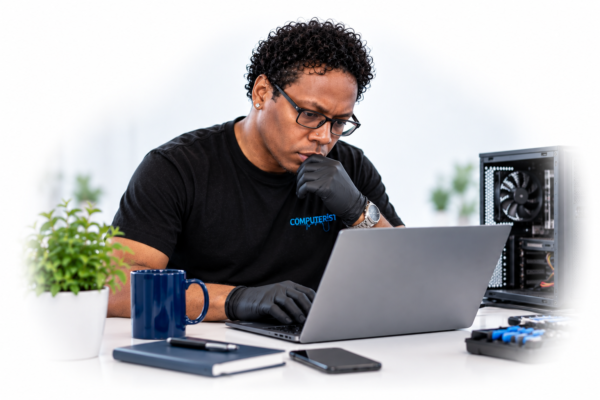 Computerist technician examining a laptop for signs of a virus or malware infection
