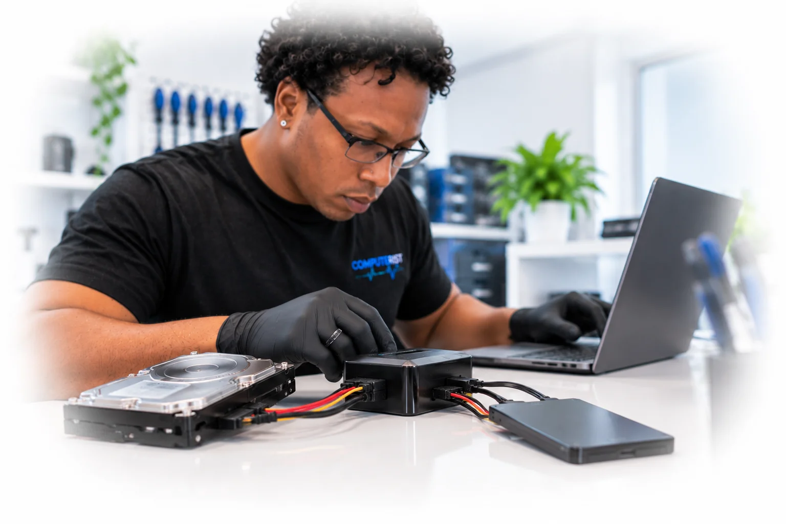 Computer technician managing a hard drive to SSD data migration.