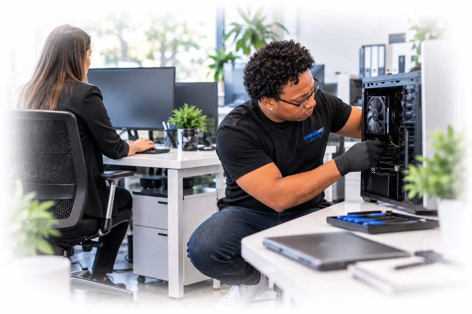 Computer technician upgrading a workstation in a modern small-business office.
