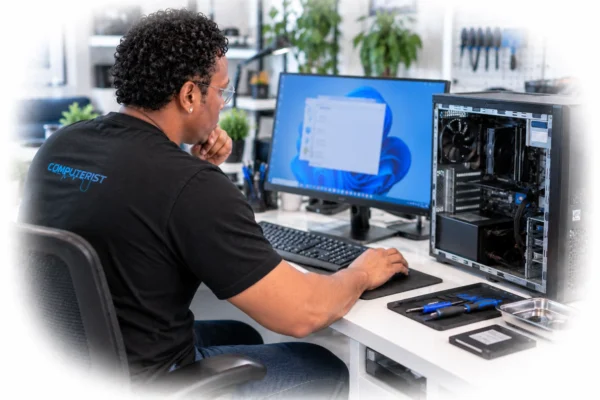 Technician diagnosing whether a computer problem is software or hardware related