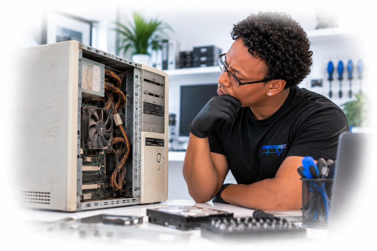 Computer technician assessing an outdated desktop before recommending further upgrades.
