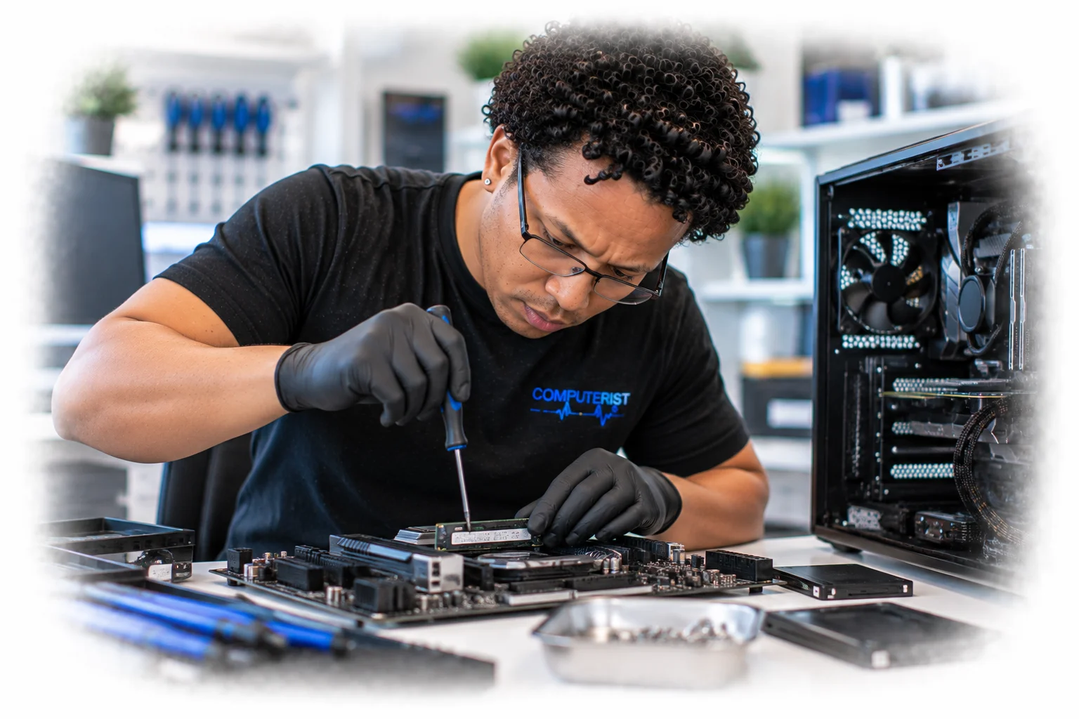 Computer technician performing hands-on hardware work with professional tools.
